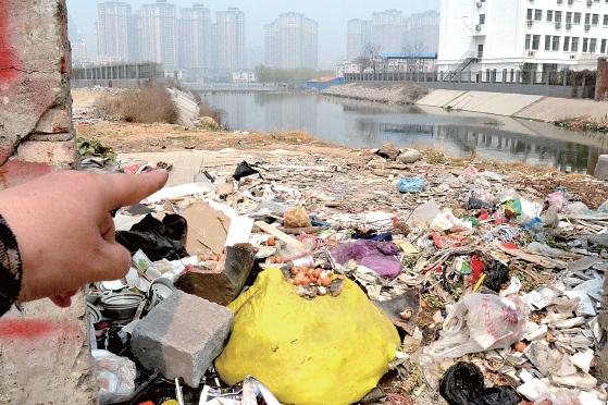 金水河長江路橋下河水發(fā)臭，水邊堆放眾多垃圾