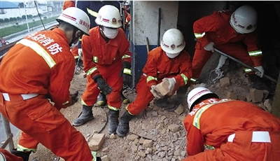 消防人員在清理熔鹽爐倒塌的廢墟。