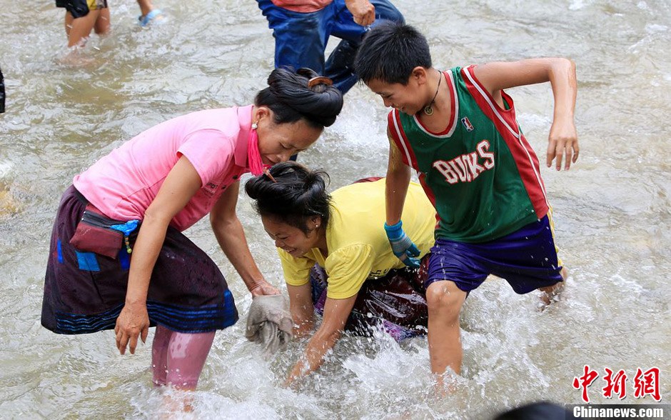 7月9日，村民在小河里摸魚(yú)搶魚(yú)。譚凱興 攝
