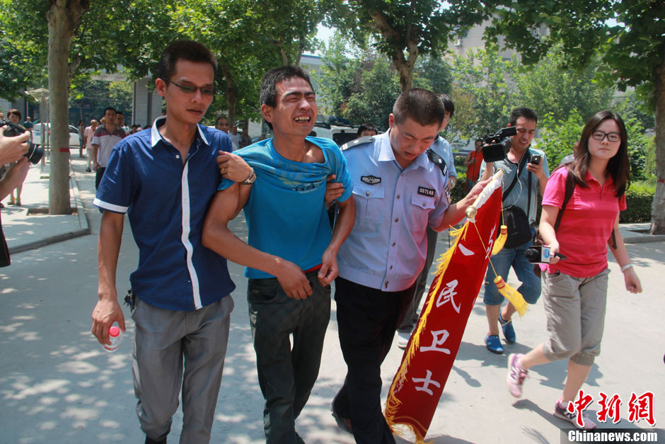 圖為獲救嬰兒父親情緒一度失控，當(dāng)?shù)鼐焦ぷ魅藛T對其進(jìn)行攙扶。張一辰 攝