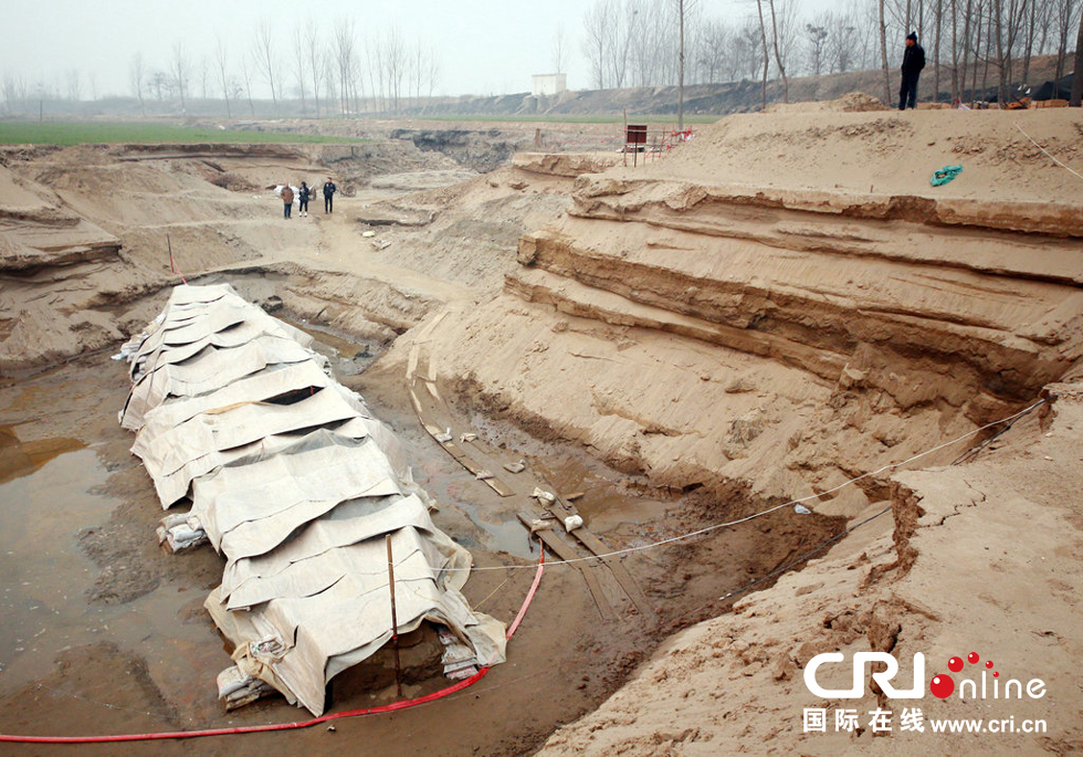 2014年1月6日，河南洛陽古沉船發(fā)掘現(xiàn)場，近日有雨雪天，考古人員給古沉船披上一層“雨衣”。