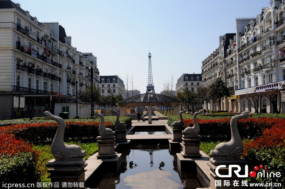 　2014年3月21日，杭州天都城，農(nóng)民在山寨埃菲爾鐵塔下耕作。圖片來(lái)源：東方IC