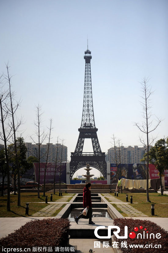 　2014年3月21日，杭州天都城，農(nóng)民在山寨埃菲爾鐵塔下耕作。圖片來(lái)源：東方IC