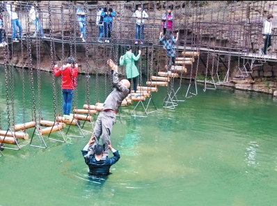中年男游客正踩著景區(qū)安全員郭小明的肩膀過河。網(wǎng)友“@我的小名叫張孩”供圖