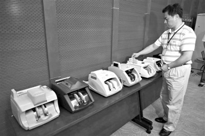 昨日，央行工作人員用各種驗(yàn)鈔機(jī)對C1F9假幣進(jìn)行測試，機(jī)器均能及時作出異常報(bào)警反應(yīng)。新京報(bào)記者 浦