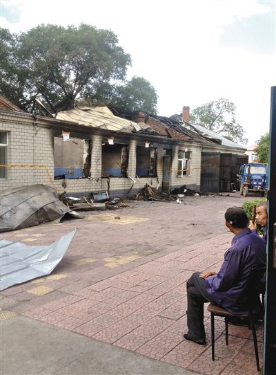 7月27日，海倫聯合敬老院內，幾名老人看著對面被燒毀的特護病房。新京報記者 涂重航 攝