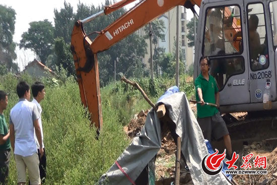 陳寶成手持自制刀斧守在挖掘機(jī)旁阻止便衣民警靠前。駕駛室內(nèi)，張朋珂正向受害人郭曉剛身上澆汽油。（視頻截圖）