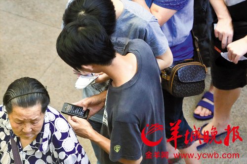 排隊(duì)的“黃?！备魇謭?zhí)一疊白紙，上面寫好了要掛號的人的信息，包括姓名、電話、要掛的科室等。穿黑白花紋衣服的老婆婆正在排隊(duì)掛號