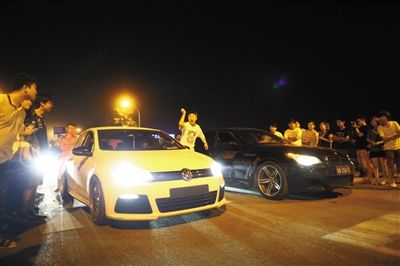 8月24日晚，東壩中街飆車現(xiàn)場(chǎng)，兩輛車并排等待出發(fā)指令，旁邊許多愛好者前來觀看比賽。新京報(bào)記者