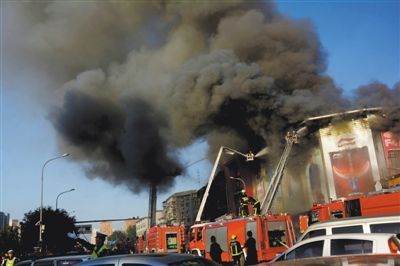 11日，蘋果園喜隆多商場，火災現(xiàn)場濃煙滾滾。新華社發(fā)