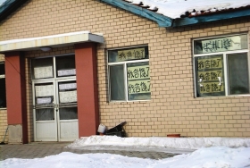 伊春市帶嶺區(qū)一排破舊的平房，房間窗戶上貼滿了“我告饒了”的字樣。