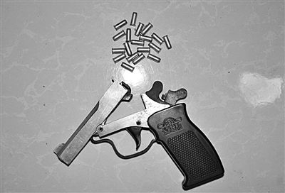 警方從搶劫嫌疑人處起獲的贓款和發(fā)令槍、子彈。警方供圖