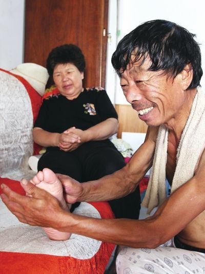 慈成富為老伴按摩。