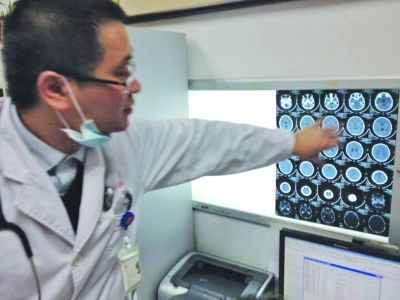 醫(yī)生在查看男孩的腦部CT片。薛馬義 攝