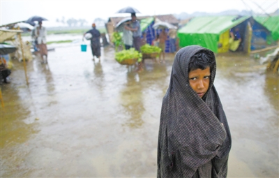5月14日，緬甸若開(kāi)邦實(shí)兌難民營(yíng)，羅興亞族難民在雨中行走。熱帶風(fēng)暴“馬哈森”即將登陸緬甸，這里的難民開(kāi)始乘船撤離。