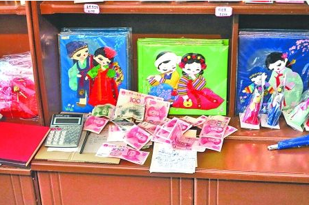 　　2012年6月21日，在朝鮮羅先特別市的一家商店里，柜臺上散落著一些人民幣。在朝鮮，人民幣比本國