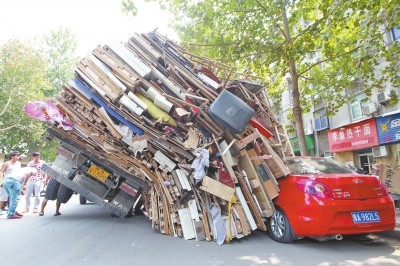 紅色小轎車被砸，卡在路邊動(dòng)彈不得。