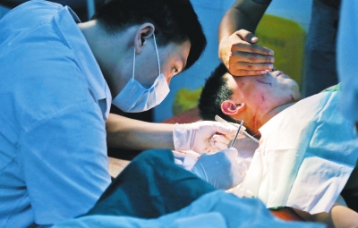 孩子身上有7道傷痕，其中兩道需要縫合，其他的均為擦傷，醫(yī)生正對他施治。