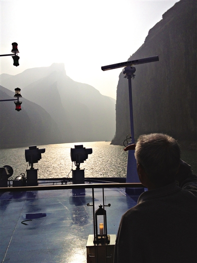 　　游客在游輪上遠(yuǎn)眺三峽風(fēng)光。