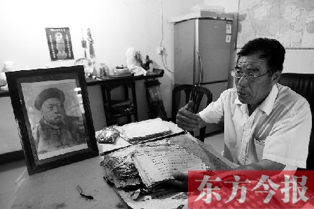 　魏樹紹手拿《物權(quán)法講義》手稿，在講訴先祖書寫“物權(quán)法”的歷史（相框里就是魏聯(lián)奎）