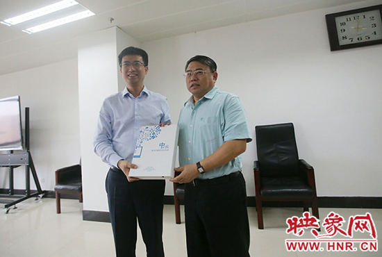 阿里云計(jì)算總裁胡曉明向河南省新聞出版廣電局局長(zhǎng)朱夏炎遞交《中原云平臺(tái)交付手冊(cè)》。