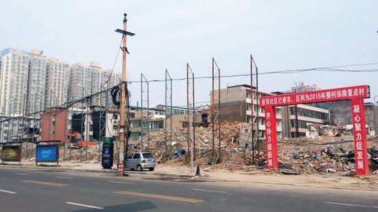 015年5月31日，在社區(qū)干部的帶頭拆遷下，親賢社區(qū)的“城中村改造”拉開帷幕。由于前期“清產核資”及補償標準等因素，拆遷改造工作推進并不順利。圖為位于體育西路東側集體所有的商鋪率先被拆遷完畢，用于遮擋的圍擋正在施工中。（拍攝：2015年9月16日）