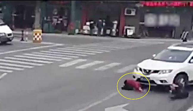 圖為小姑娘被卷進(jìn)車輪下瞬間。