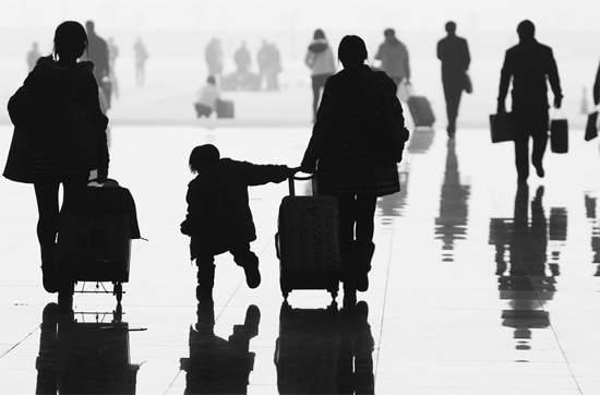 昨日，鄭州東站，一名孩子拉著媽媽和包裹快樂地奔走在春運(yùn)的途中