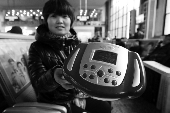 火車站候車室，李女士向記者展示她準(zhǔn)備孝敬父母的按摩儀
