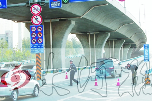 交警在東風路從北向南上橋口處擺上反光錐，間歇放行