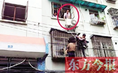 施救現(xiàn)場，劉鵬（圈內(nèi)）先用繩子捆住老太確保安全 勞動報記者 郭娜 供圖