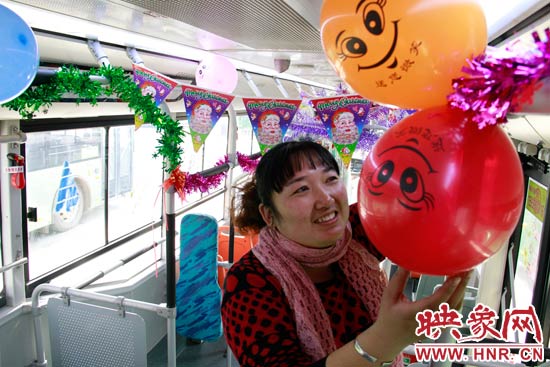 鄭州快速公交B3區(qū)間線車長李鵬云在車廂里懸掛氣球，布置圣誕車廂，營造歡樂圣誕氛圍