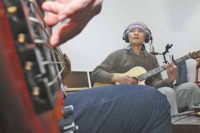 抱著吉他撥弄琴弦，子芙唱著自己的音樂(lè)。