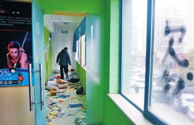 　健身會所地上一片狼藉，玻璃上噴著黑色“欠錢”二字。