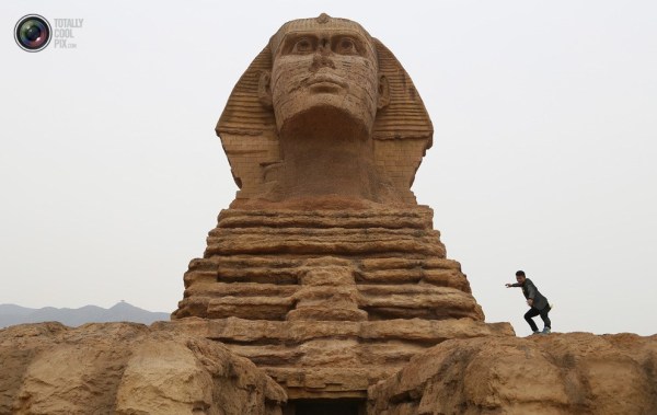 石家莊郊外，一名男子與山寨版獅身人面像合影留念。