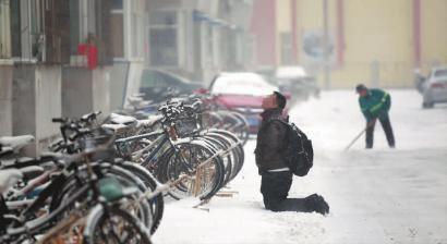 小伙子跪在樓前，一直抬頭看著樓上。 孫立國/攝