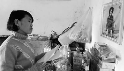 錢仁鳳站在母親遺像前。未能見母親最后一面是她的一大遺憾。