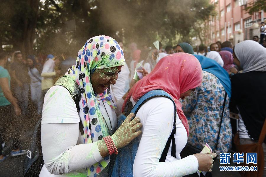 10月16日，在埃及首都開羅，兩名女青年在“彩色跑”活動(dòng)中躲避人們拋撒的彩色粉末。