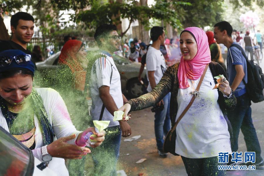 10月16日，在埃及首都開羅，一名女青年在“彩色跑”活動(dòng)中拋撒彩色粉末。