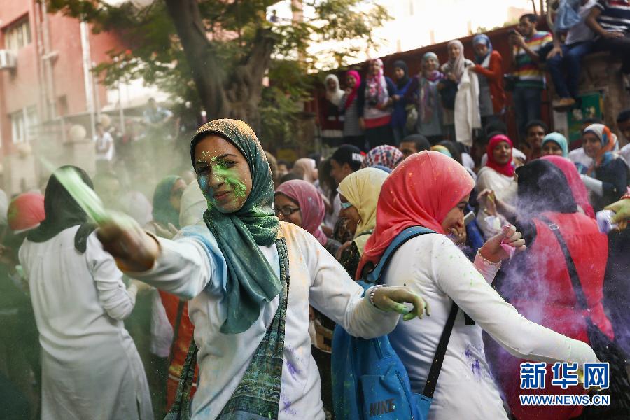 10月16日，在埃及首都開羅，一名女青年在“彩色跑”活動(dòng)中拋撒彩色粉末。