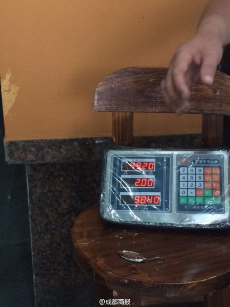 父子倆為大魚(yú)量體重。