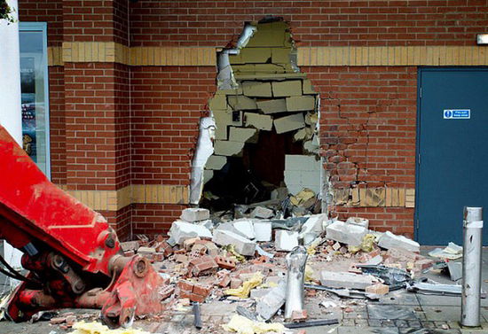 劫匪利用挖掘機(jī)的機(jī)械臂移走ATM機(jī)，留下滿地狼藉