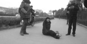 鄭大姐坐在地上，警方趕到進(jìn)行施救。（視頻截圖由警方提供）