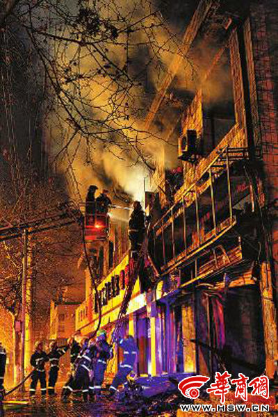 昨日22時(shí)10分，西安市豐慶路南小巷南口，消防官兵架梯子登上二樓施救 本組圖片由本報(bào)記者 閆文青 攝