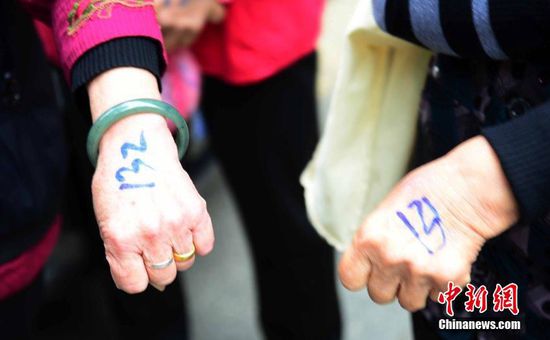 圖為10月28日，在江西九江市一家羊絨皮草服裝服飾博覽會現(xiàn)場，老人們正在頂著寒風(fēng)排隊等待領(lǐng)取10元代金劵。