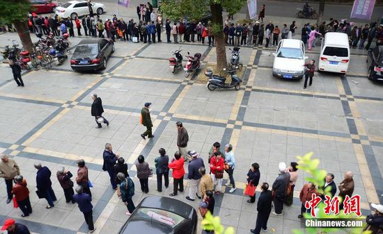 圖為10月28日，在江西九江市一家羊絨皮草服裝服飾博覽會現(xiàn)場，老人們正在頂著寒風(fēng)排隊等待領(lǐng)取10元代金劵。