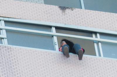 28樓的窗臺上坐著一名女子，其兩條腿耷拉在室外，不停地擺動。