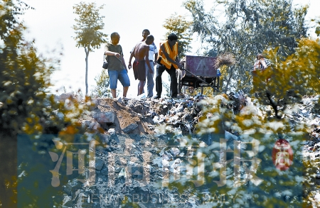 有人正在傾倒建筑垃圾，不遠(yuǎn)處就是村民的水井