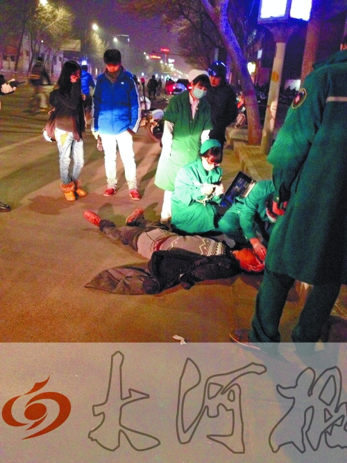 醉漢躺在地上，醫(yī)護(hù)人員對(duì)其進(jìn)行檢查。